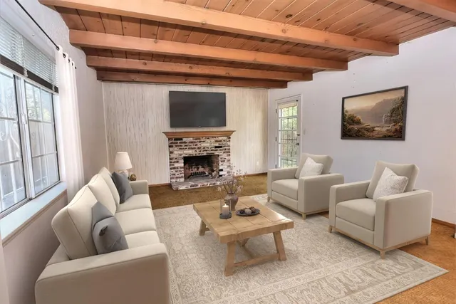 a living room with furniture a flat screen tv and a fireplace