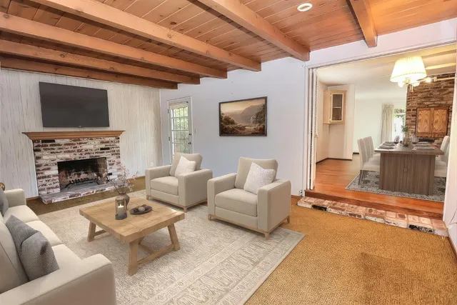 a living room with furniture a flat screen tv and a fireplace