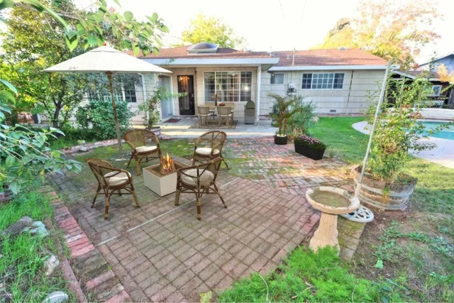 a view of a house with backyard sitting area and garden