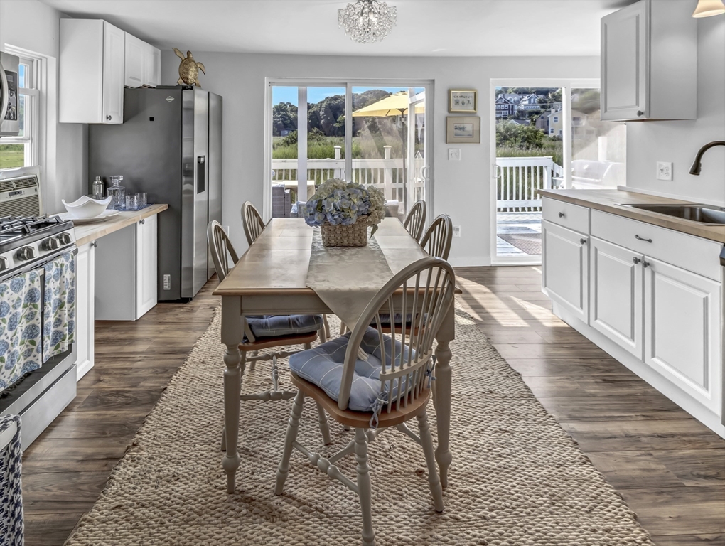 3 Bay View Street Hull, MA 02045 - Photo 11 of 39 a kitchen with stainless steel appliances kitchen island granite countertop a refrigerator a stove a sink dishwasher with a dining table and chairs