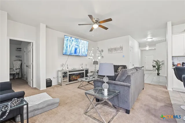 a living room with furniture a fireplace and a chandelier