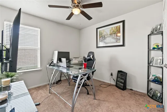 a view of a workspace with furniture and a window