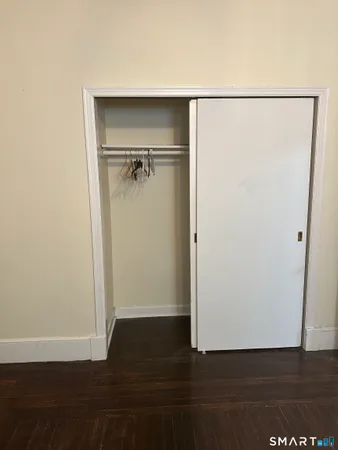 a view of walk in closet with wooden floor