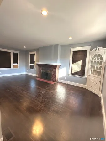 an empty room with windows and fireplace