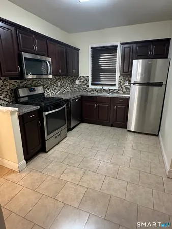 a kitchen with stainless steel appliances a refrigerator sink and stove