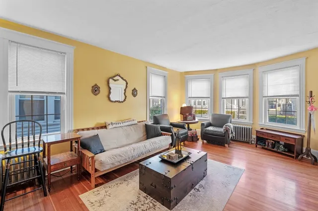 a living room with fireplace furniture and floor to ceiling windows