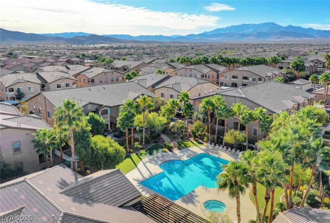 8985 South Durango Drive, Unit 2187 Las Vegas, NV 89113 - Photo 46 of 73 An aerial perspective reveals a vibrant community pool with surrounding palm trees and mountain vistas.