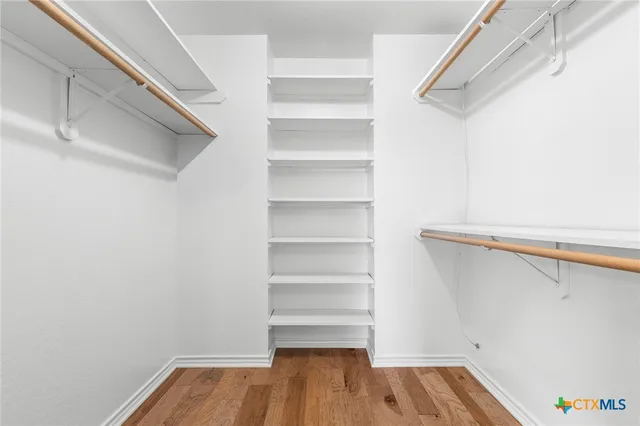 a view of walk in closet with empty racks