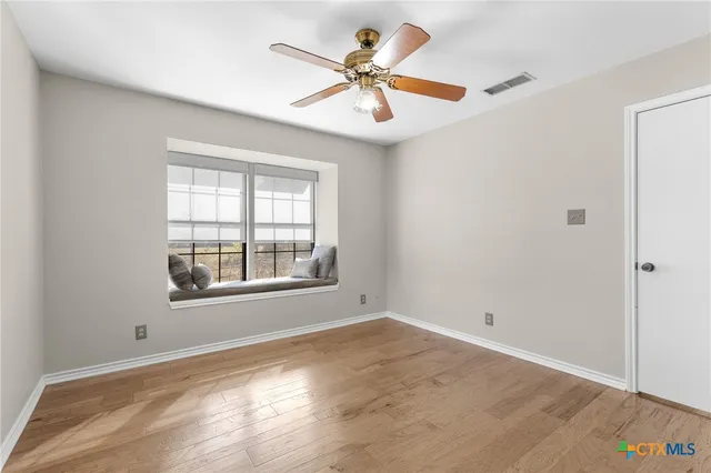 wooden floor in an empty room with a window