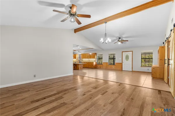 a view of an empty room with window and wooden floor