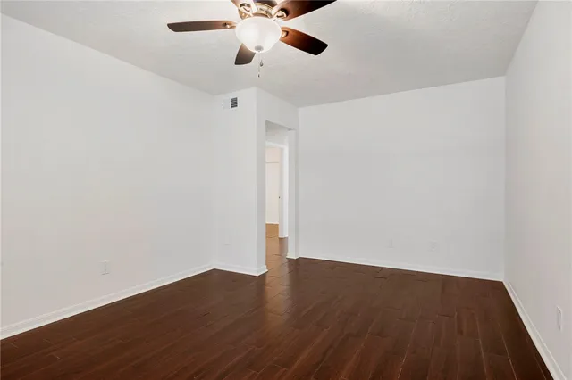 a view of an empty room with wooden floor