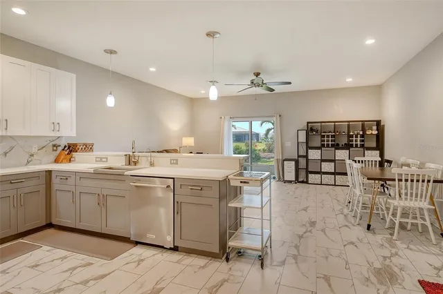 a large kitchen with cabinets chairs and chandelier