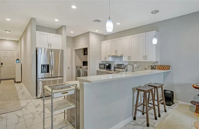 a kitchen with stainless steel appliances granite countertop a refrigerator and a stove top oven