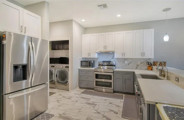 a kitchen with a refrigerator sink and stove