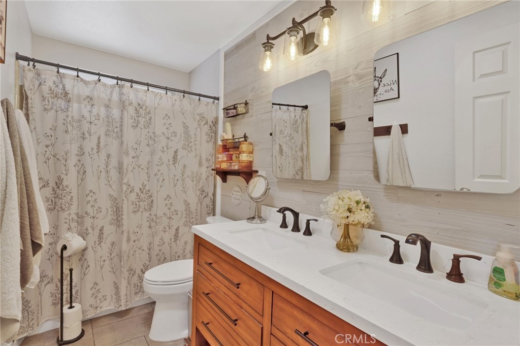 19655 Seneca Road Apple Valley, CA 92307 - Photo 14 of 67 a bathroom with a sink a toilet and shower curtain