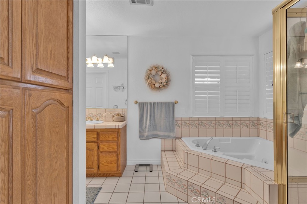 19655 Seneca Road Apple Valley, CA 92307 - Photo 26 of 67 a bathroom with a bathtub and a shower
