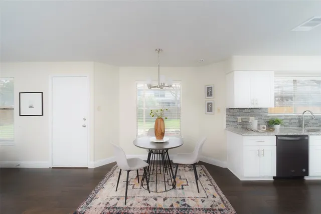 a dining room with wooden floor and a chandelier