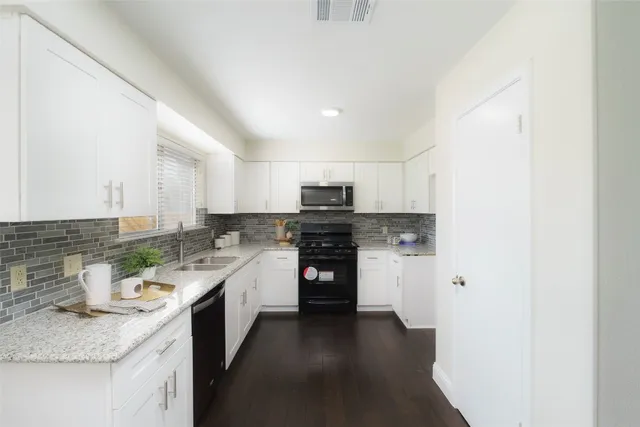 a kitchen with stainless steel appliances granite countertop a sink and stove top oven
