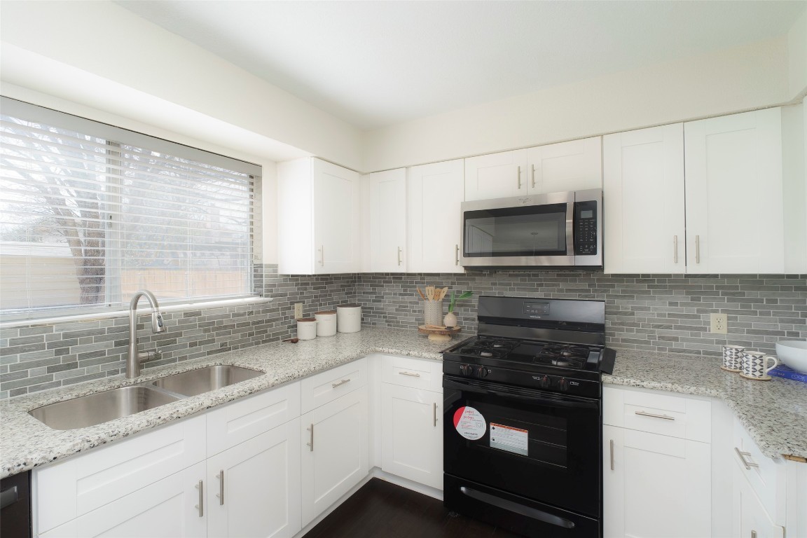 2201 Broughton Court Austin, TX 78727 - Photo 4 of 31 a kitchen with a sink cabinets and stainless steel appliances