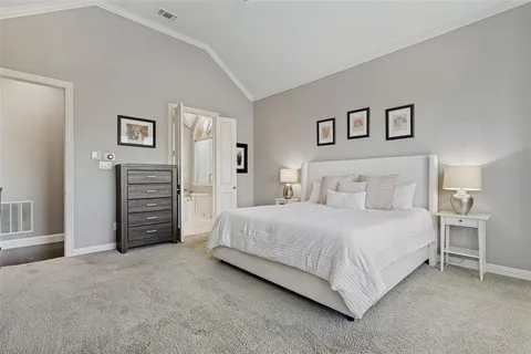a spacious bedroom with a bed and a lamp