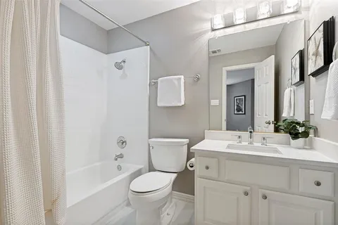 a bathroom with a double vanity sink toilet mirror and bathtub