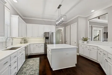 a large white kitchen with stainless steel appliances sink and cabinets