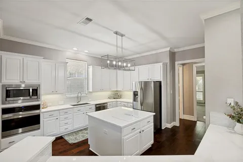 a kitchen that has a lot of cabinets in it and appliances