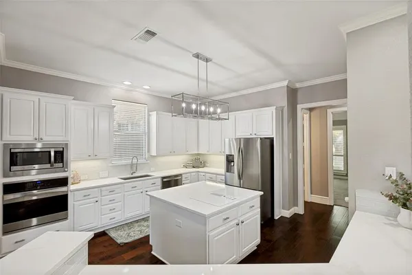 a kitchen that has a lot of cabinets in it and appliances