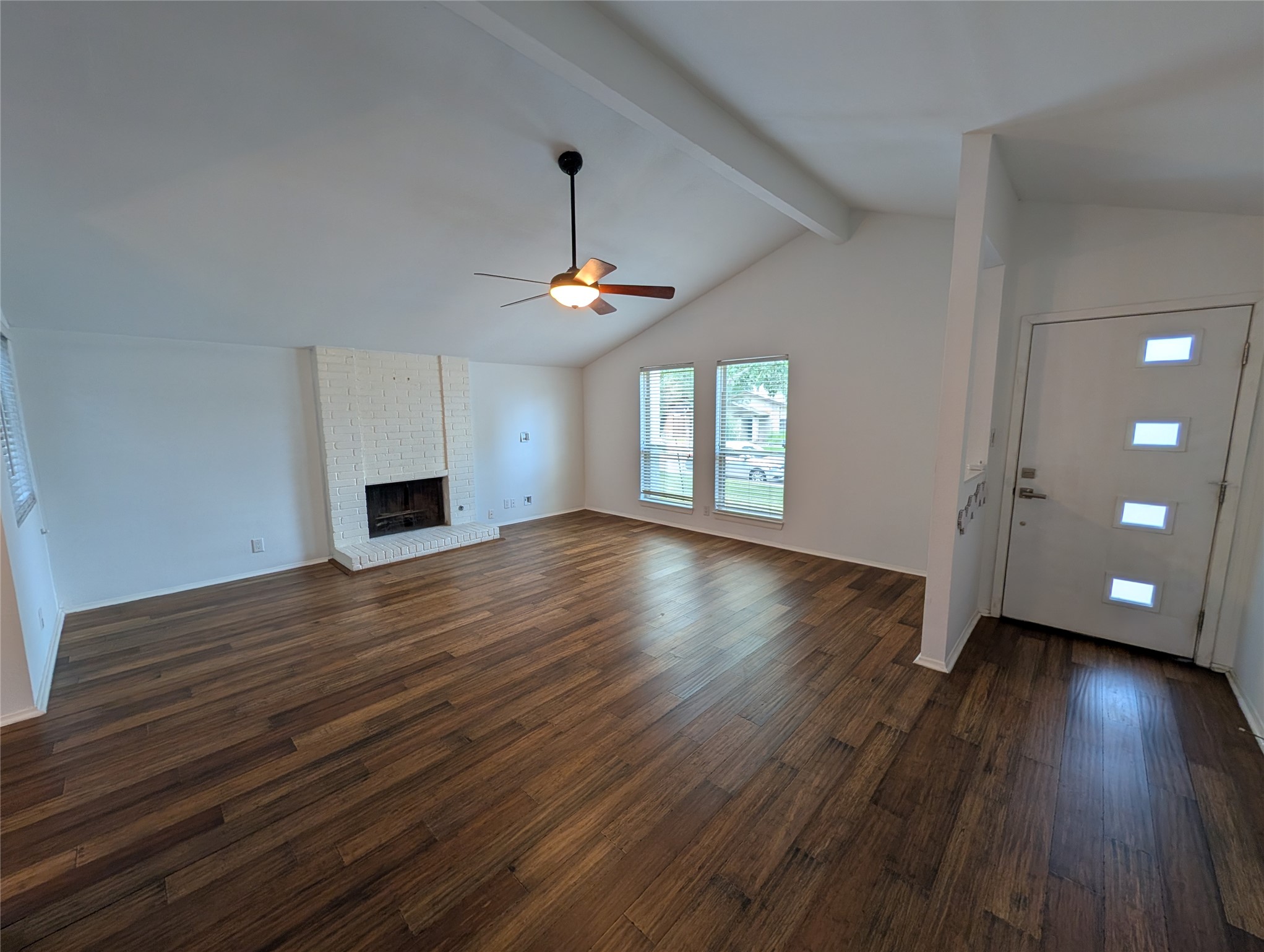 4601 Tamarack Trail Austin, TX 78727 - Photo 3 of 19 A spacious living area featuring vaulted ceilings, rich hardwood flooring, and a classic brick fireplace.
