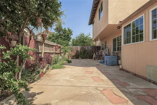 a view of white house with a chairs in patio