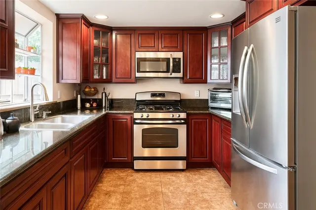 a kitchen with stainless steel appliances granite countertop a refrigerator stove and sink