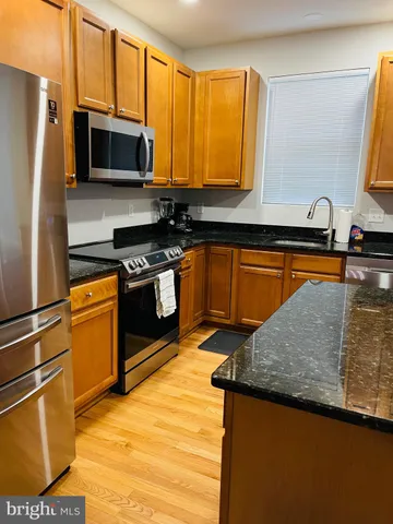a kitchen with stainless steel appliances granite countertop a stove a sink dishwasher and a refrigerator