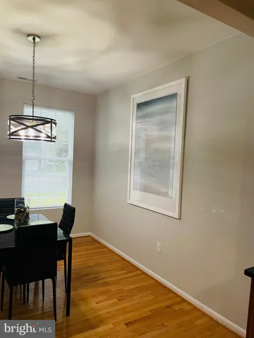 a view of a room with a table chairs and wooden floor