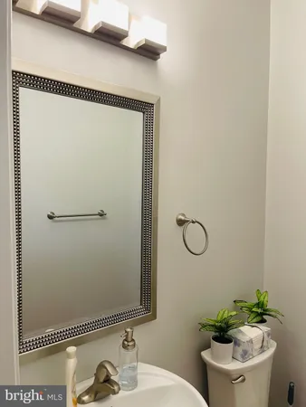 a bathroom with a granite countertop sink a toilet and a mirror