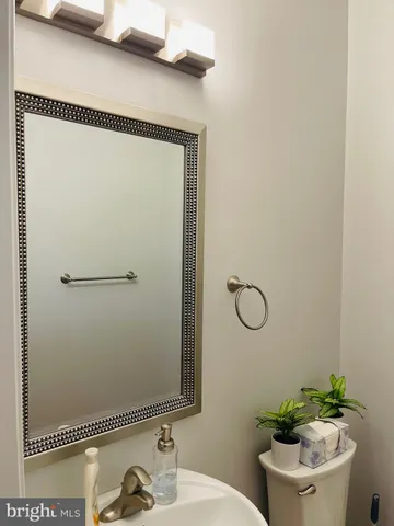 a bathroom with a granite countertop sink a toilet and a mirror