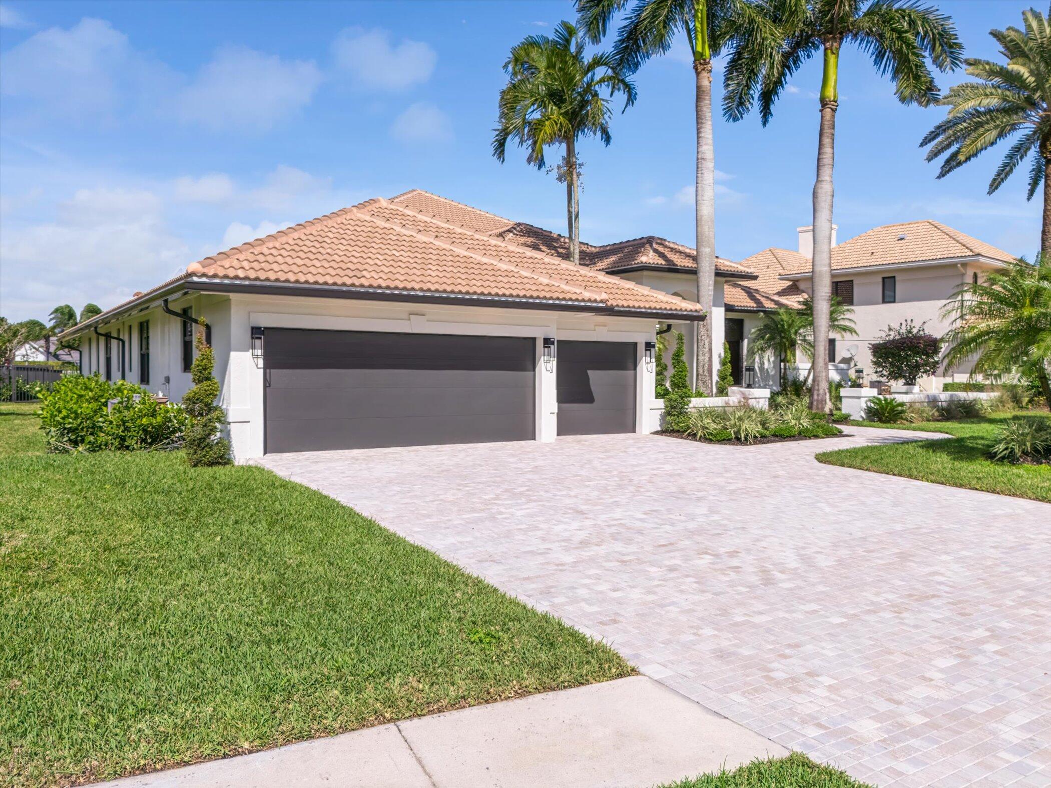 4459 Bocaire Boulevard Boca Raton, FL 33487 - Photo 51 of 72 a front view of a house with a garden and yard