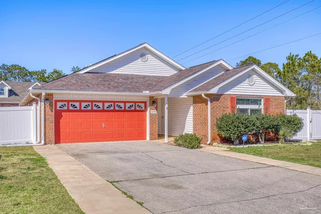 a front view of a house with a yard and potted plants