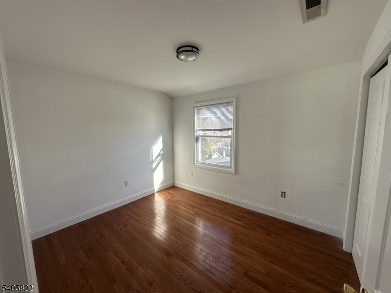 26 Van Rensselear Street, Unit 3 Belleville, NJ 07109 - Photo 5 of 12 a view of an empty room with wooden floor and a window