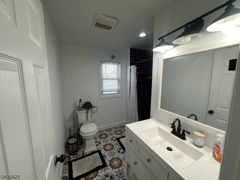 26 Van Rensselear Street, Unit 3 Belleville, NJ 07109 - Photo 7 of 12 a bathroom with a sink toilet and mirror