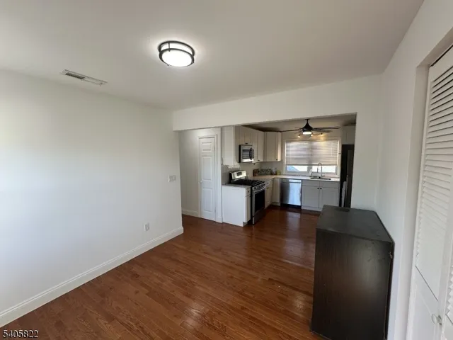 a view of a kitchen with wooden floor and a refrigerator