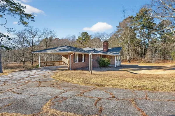 a front view of a house with a yard and trees