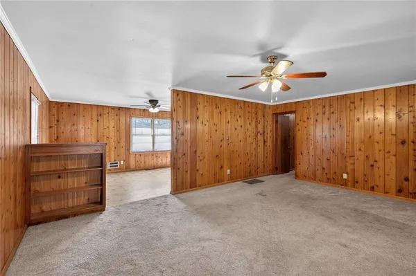 an empty room with closet and ceiling fan