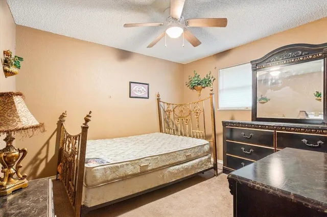 a bedroom with a bed and dresser with mirror