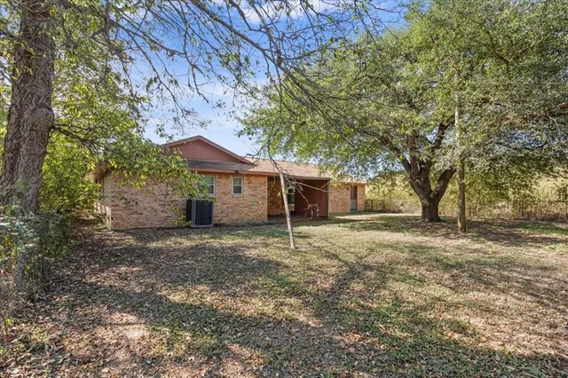 a backyard of a house with table and chairs