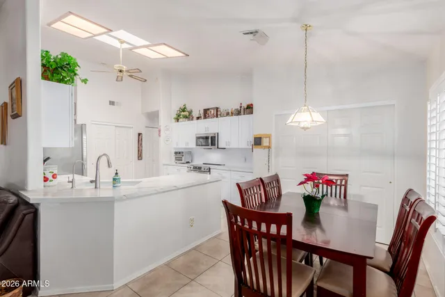 a kitchen with a dining table chairs and white cabinets