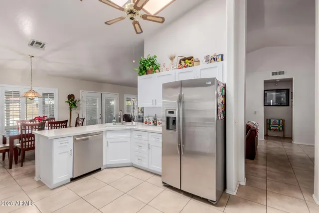 a kitchen with stainless steel appliances a refrigerator sink and white cabinets