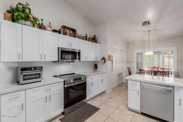 a kitchen with white cabinets and white appliances
