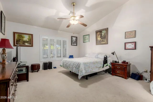 a spacious bedroom with a bed and a chandelier