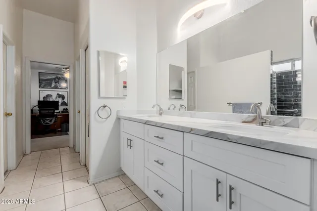 a spacious bathroom with a granite countertop sink and a mirror