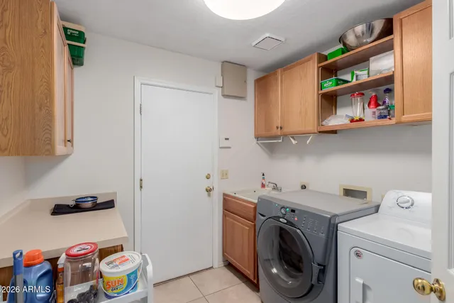 a utility room with dryer washer and shoe rack